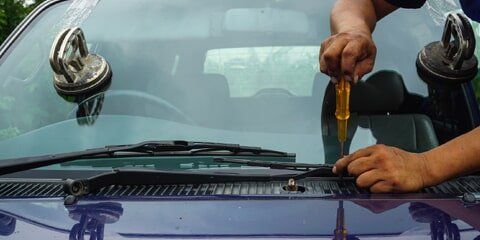 Windshield chip repair technician at work